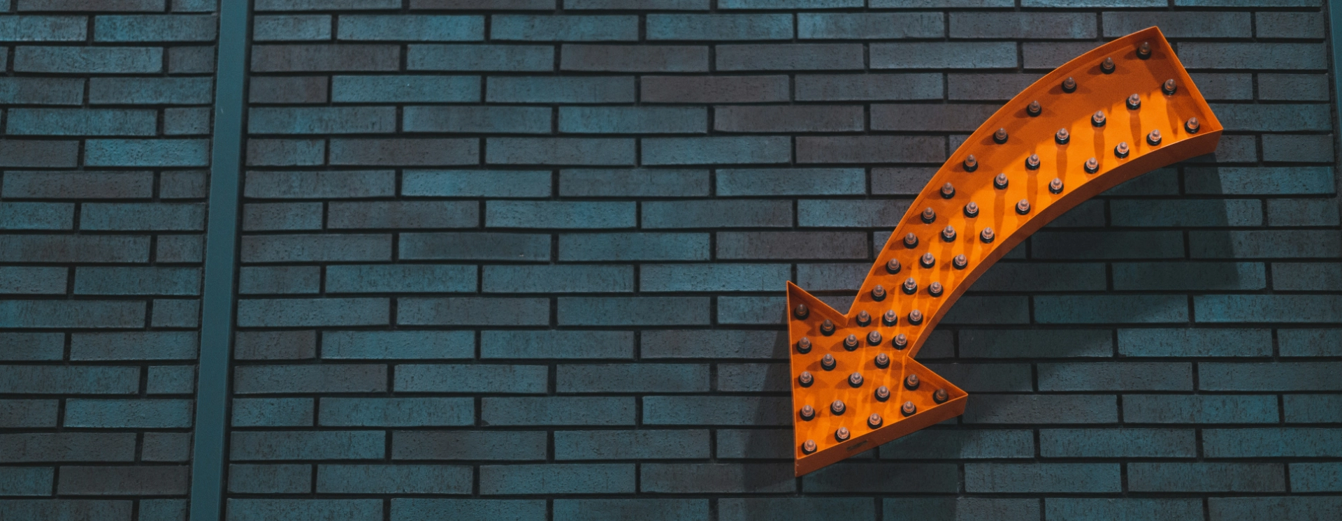 Lefelé mutató nyíl téglafalon